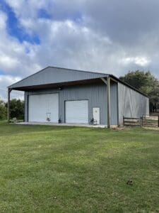 A large metal building with two doors and a porch.